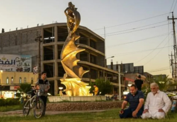 مصلون قرب تمثال "السيدة الجميلة" في 18 أغسطس 2020 في الموصل-فرانس برس