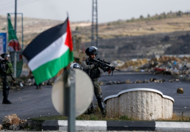 العلم الفلسطيني في مقابل جنود من جيش الاحتلال بالضفة الغربية-أرشيفية