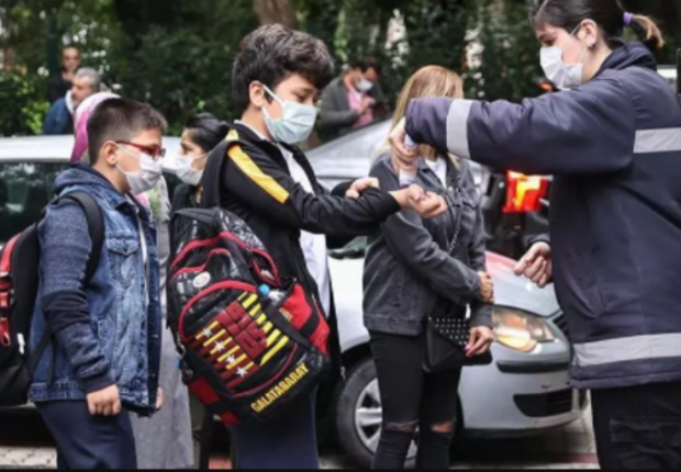 طلبة في تركيا يعقمون أياديهم قبل دخول المدرسة