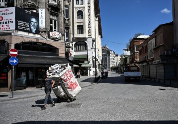 جامع قمامة يسير على طول شارع مهجور في منطقة إمينونو بإسطنبول