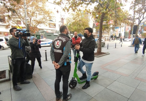 ضابط شرطة يتحدث مع راكب دراجة بخارية أثناء عمليات تفتيش في اسطنبول