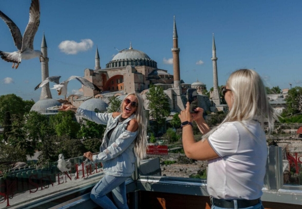 سائحات يلتقطن صورا بالقرب من مسجد آيا صوفيا في إسطنبول