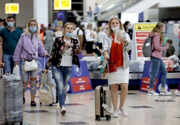سائحون روس يسيرون في مطار في مقاطعة أنطاليا