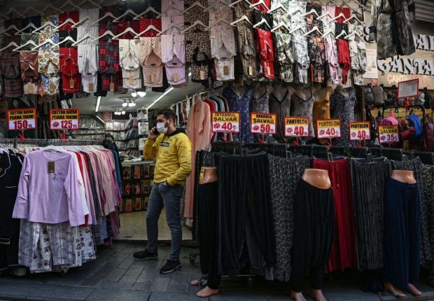 صاحب متجر يتحدث بهاتفه المحمول في منطقة محمود باشا، أحد أكبر مراكز تسوق المنسوجات في إسطنبول