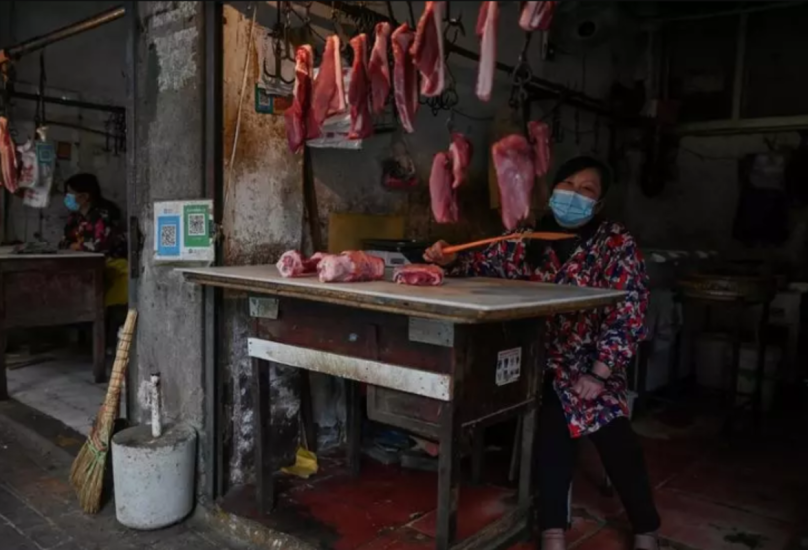 سيدة تبيع اللحم في أحد أسواق ووهان الشعبية وسط الصين-فرانس برس