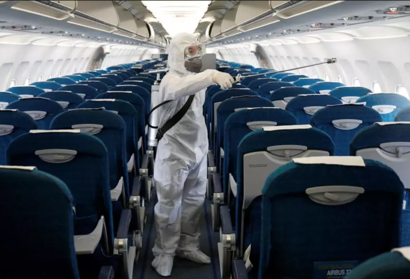 عامل يرش مطهرًا داخل طائرة تابعة لشركة الخطوط الجوية الفيتنامية-رويترز