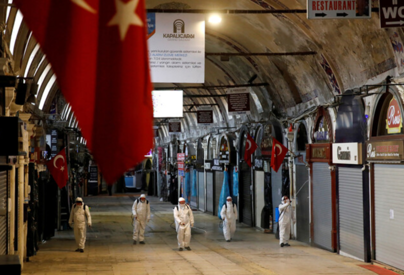 عاملون يعقمون أحد الأسواق خلال الليل في تركيا-رويترز