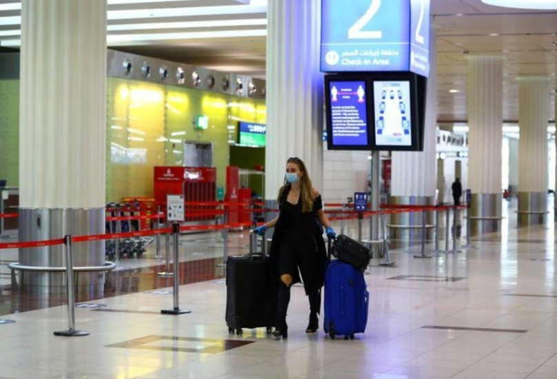 مسافرة تضع كمامة للوقاية من فيروس كورونا في مطار دبي الدولي