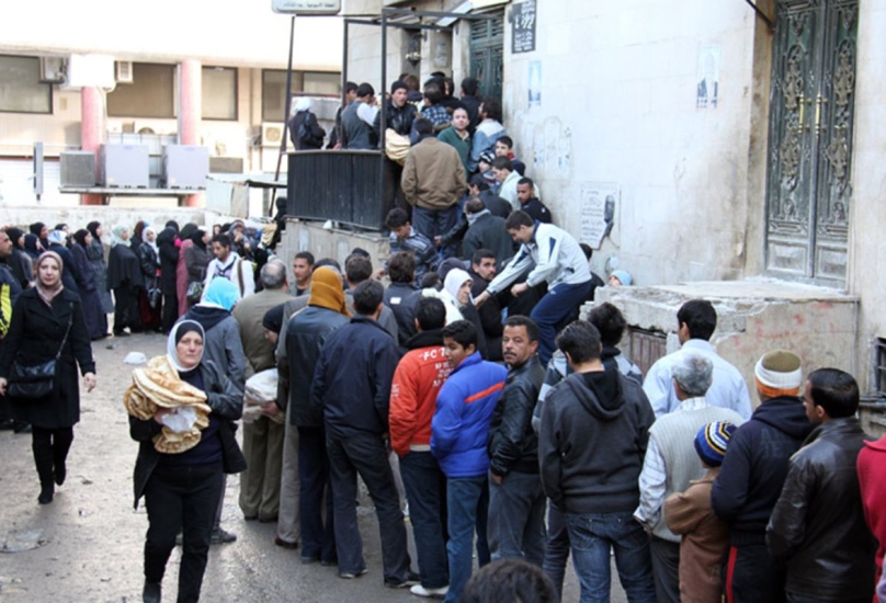 سوريون يتجمعون عند أحد المخابز في دمشق-أرشيفية