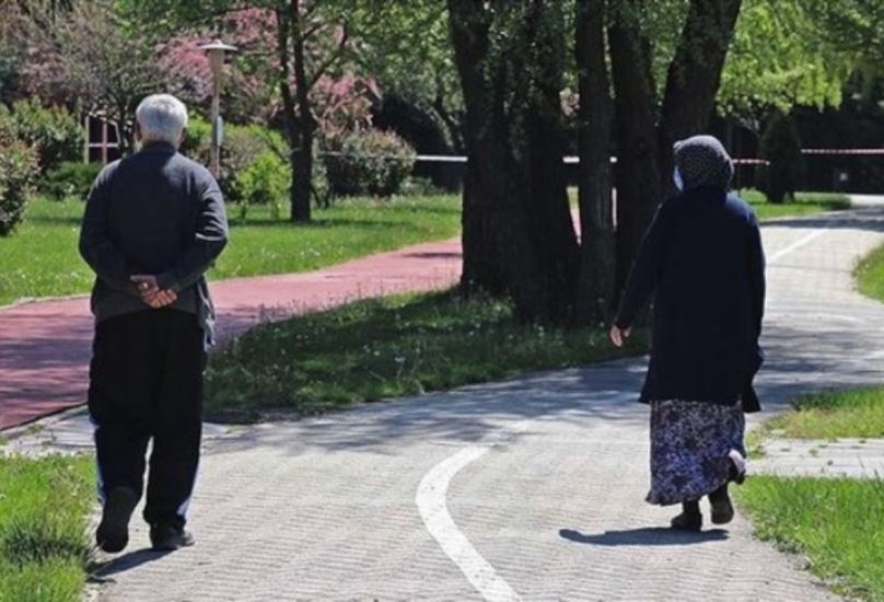 مواطنان مسنان يمتثلان أثناء سيرهما لقاعدة المسافة الاجتماعية