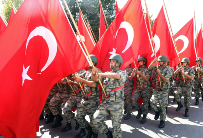 جنود أتراك يسيرون بالأعلام الوطنية أثناء عرض عسكري-أرشيف