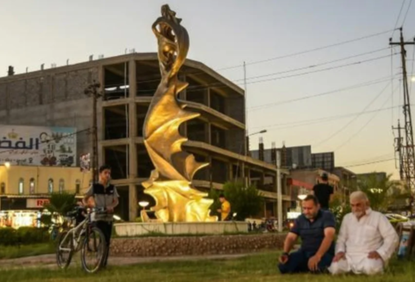 مصلون قرب تمثال السيدة الجميلة في 18 أغسطس 2020 في الموصل-فرانس برس
