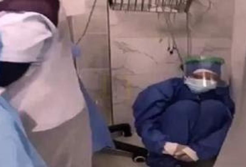 ممرضة تجلس على الأرض مصدومة مما جرى