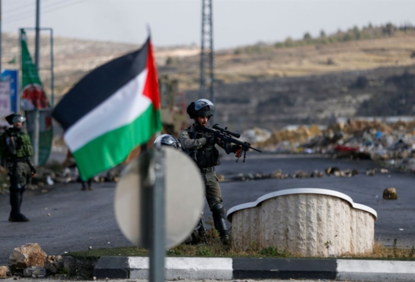 العلم الفلسطيني في مقابل جنود من جيش الاحتلال بالضفة الغربية-أرشيفية