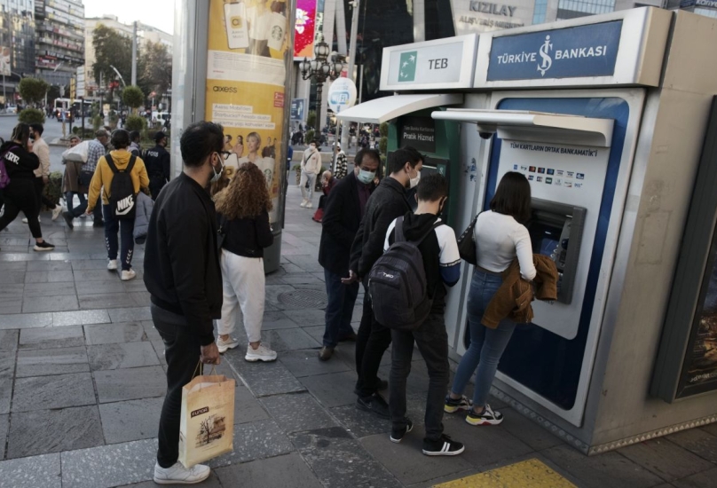 أشخاص يصطفون لاسترداد الأموال من ماكينة صراف آلي لبنك في أنقرة