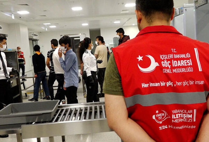 عناصر من دائرة الهجرة التركية تتم إجراءات ترحيل مهاجرين غير شرعيين في اسطنبول
