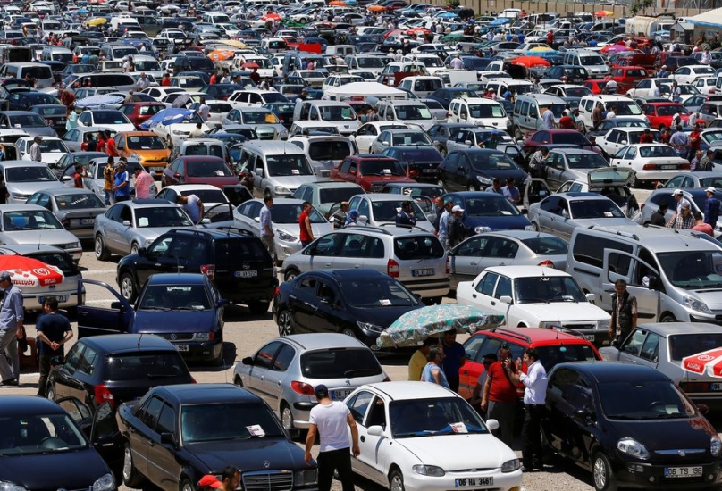عملاء يتجولون بين السيارات في سوق مفتوح في أنقرة-رويترز
