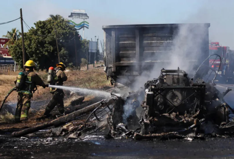 رجال الإطفاء يطفئون النار في سيارة أضرمها أعضاء عصابات المخدرات في مازاتلان بالمكسيك