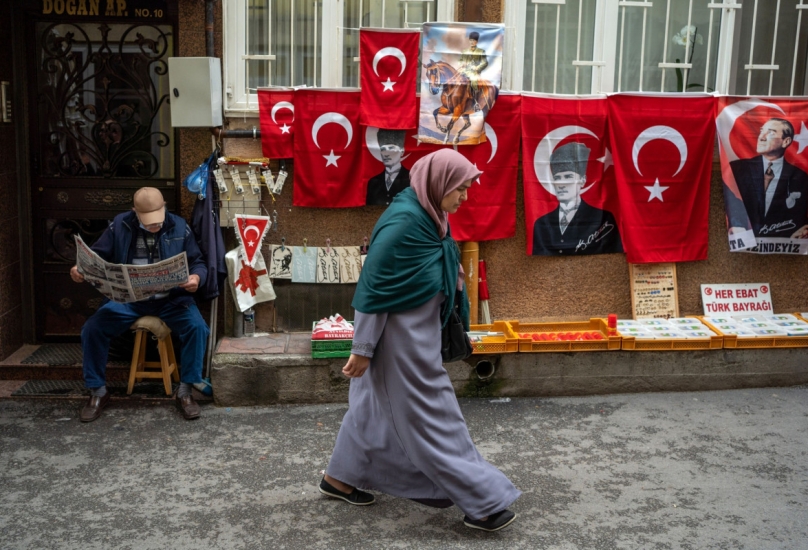 بائع متجول يبيع أعلاماً وطنية تركية مزينة بصورة كمال أتاتورك، مؤسس الجمهورية التركية، في مدينة بورصة